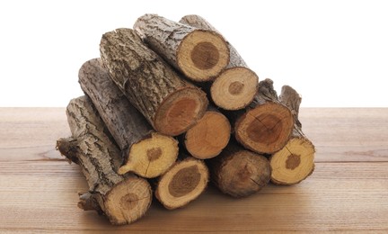 Photo of Pile of cut firewood on wooden table against white background