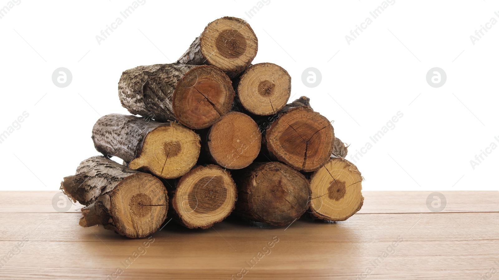Photo of Pile of cut firewood on wooden table against white background