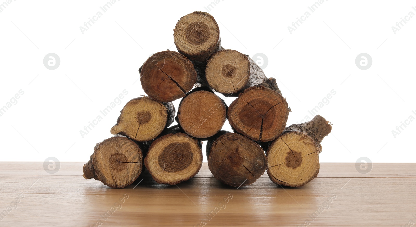 Photo of Pile of cut firewood on wooden table against white background