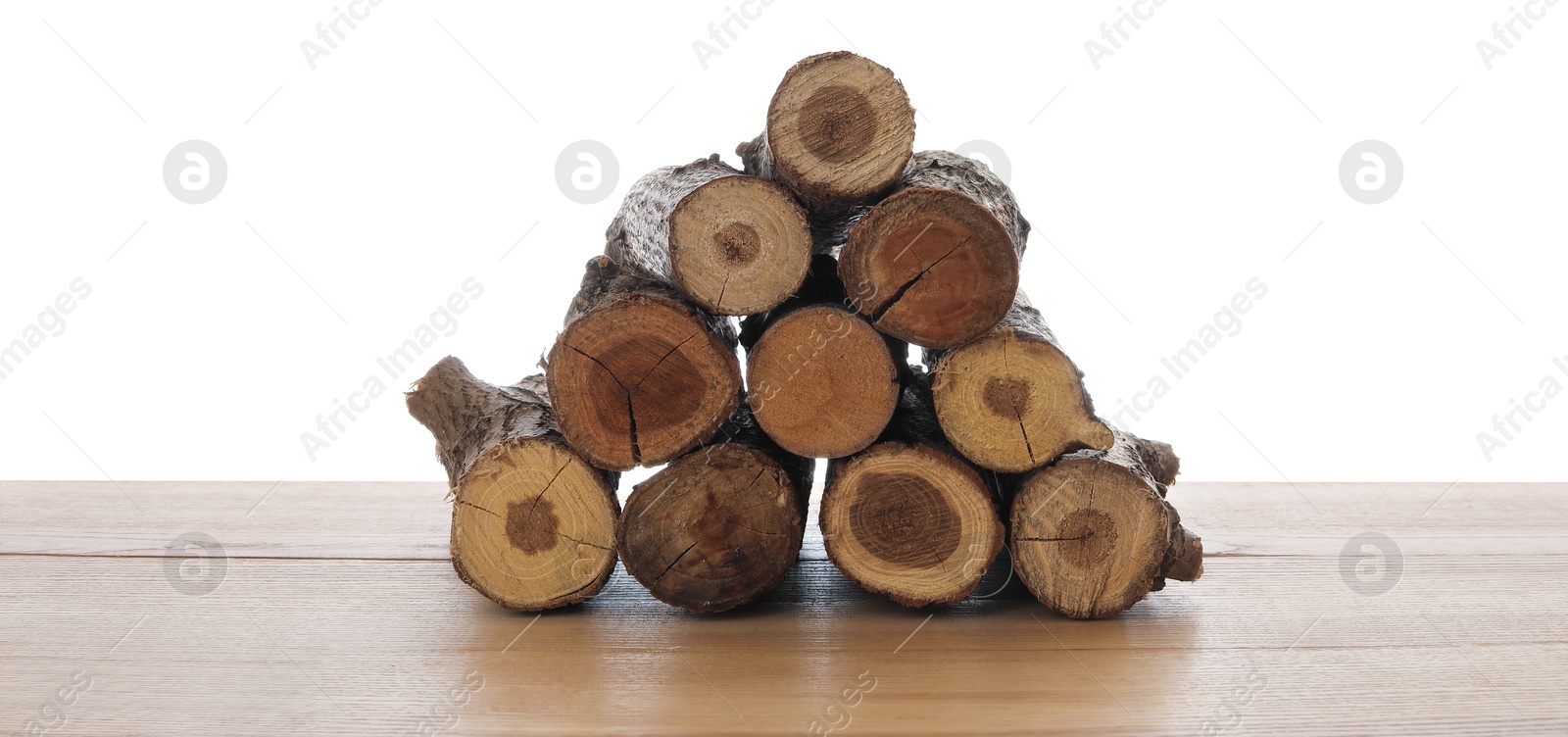 Pile of cut firewood on wooden table against white background Photo of Pile of cut firewood on wooden table against white background