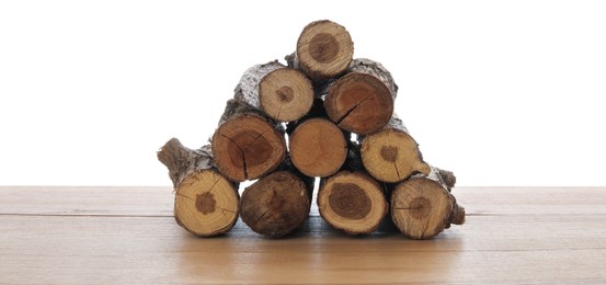 Photo of Pile of cut firewood on wooden table against white background
