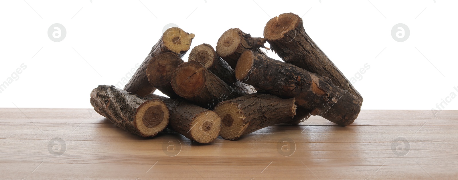 Photo of Pile of cut firewood on wooden table against white background