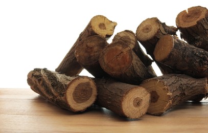 Photo of Pile of cut firewood on wooden table against white background
