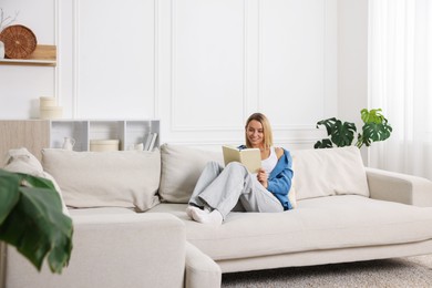 Photo of Woman reading book on sofa at home