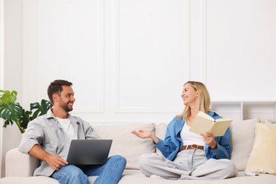 Photo of Happy couple spending time enjoying their hobbies on sofa at home