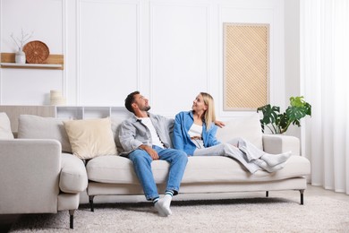 Photo of Happy couple spending time together on sofa at home
