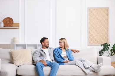 Photo of Happy couple spending time together on sofa at home