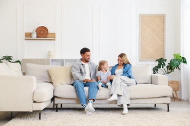 Photo of Happy family spending time together on sofa at home