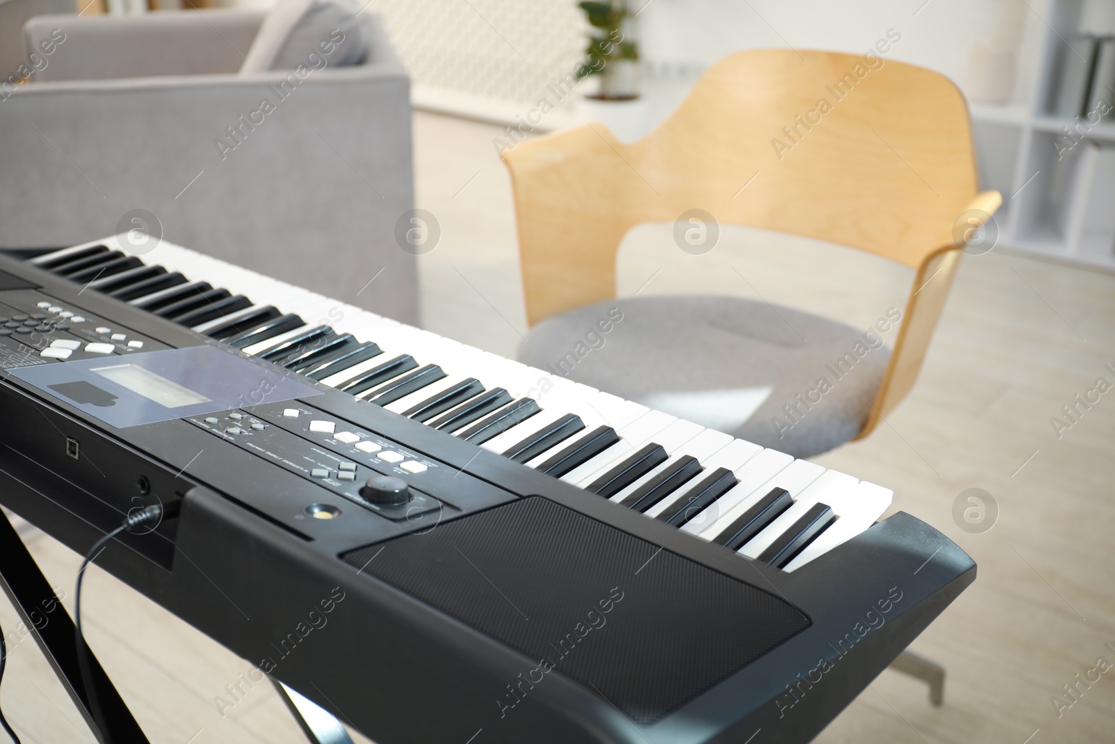 Photo of Modern electric piano and chair indoors, closeup