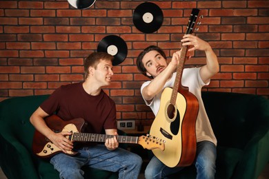 Photo of Tutor teaching man to play guitar indoors