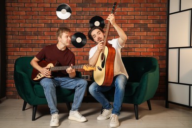 Photo of Tutor teaching man to play guitar indoors