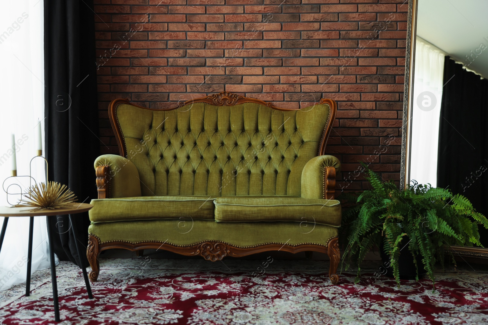 Green retro sofa, mirror, decor and houseplant in room. Interior design Photo of Green retro sofa, mirror, decor and houseplant in room. Interior design