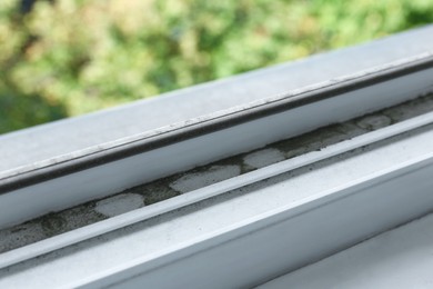 Photo of Window frame covered with dust indoors, closeup