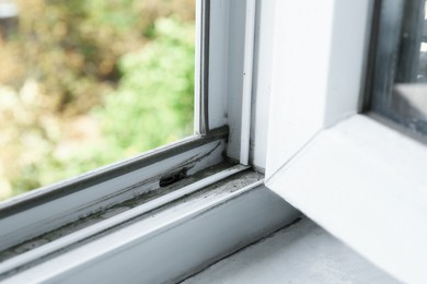 Photo of Window frame covered with dust indoors, closeup