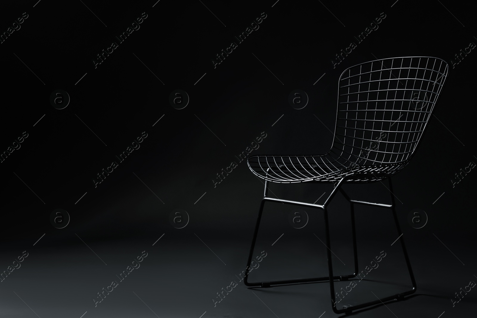 Photo of Stylish chair on black background, space for text. Used stuff
