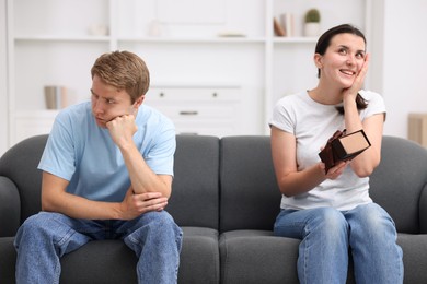Photo of Man feeling jealous of woman receiving gift at home