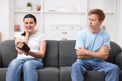 Photo of Man feeling jealous of woman receiving gift at home