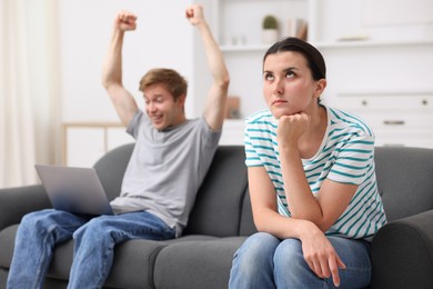 Photo of Woman feeling jealous of man's success at home, selective focus