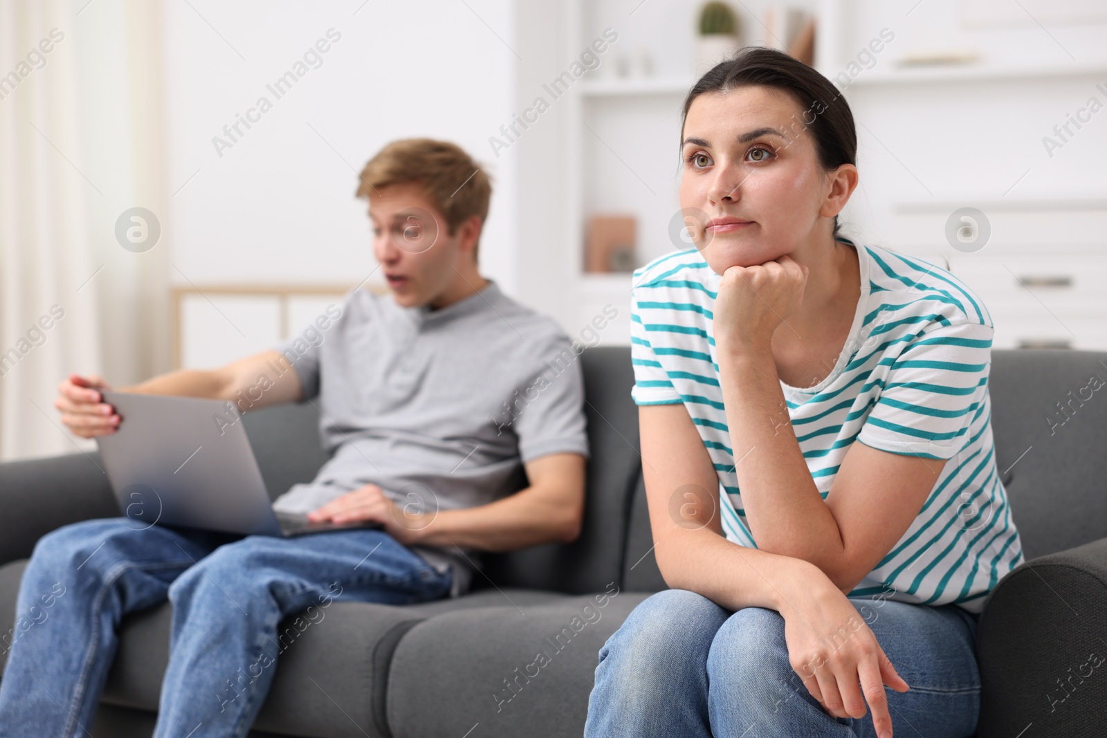 Photo of Woman feeling jealous of man's success at home, selective focus