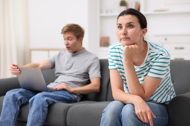 Photo of Woman feeling jealous of man's success at home, selective focus
