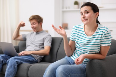 Photo of Woman feeling jealous of man's success at home, selective focus