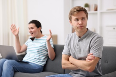 Photo of Man feeling jealous of woman's success at home, selective focus
