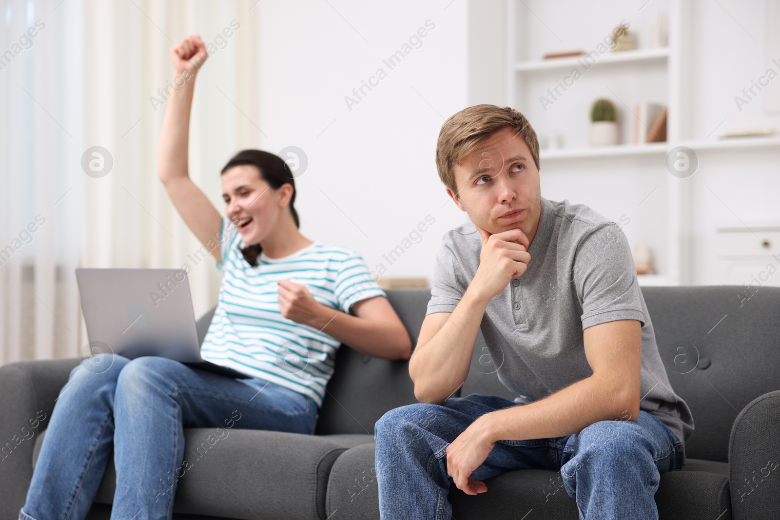 Photo of Man feeling jealous of woman's success at home, selective focus