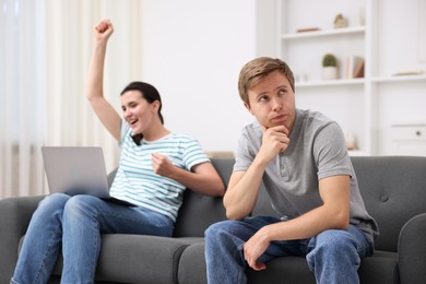 Photo of Man feeling jealous of woman's success at home, selective focus