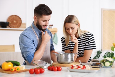 Photo of Couple cooking together at table in kitchen