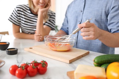 Photo of Couple cooking together at table indoors, closeup