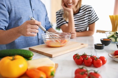Photo of Couple cooking together at table indoors, closeup