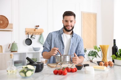 Photo of Smiling man cooking at table in kitchen