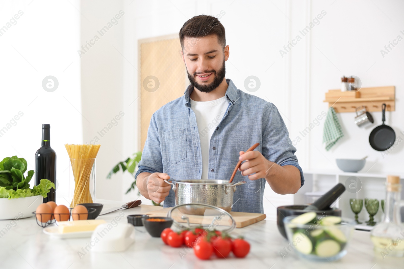 Photo of Smiling man cooking at table in kitchen