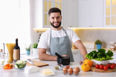Photo of Smiling man cooking at table in kitchen