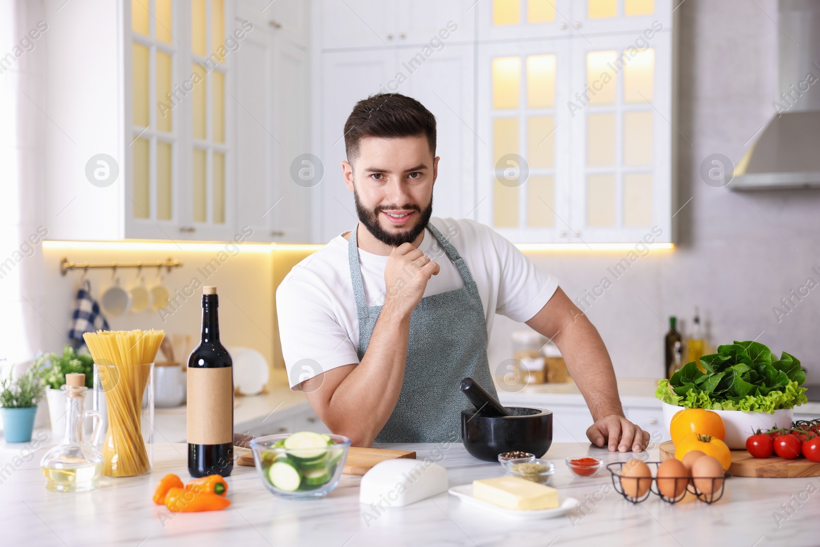 Photo of Smiling man cooking at table in kitchen