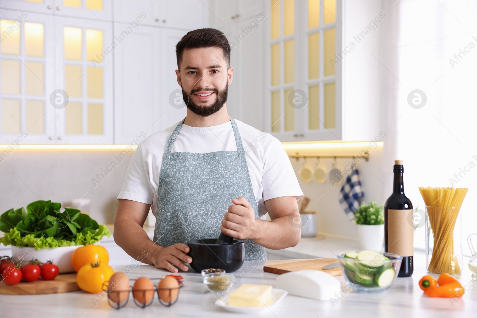 Photo of Smiling man cooking at table in kitchen