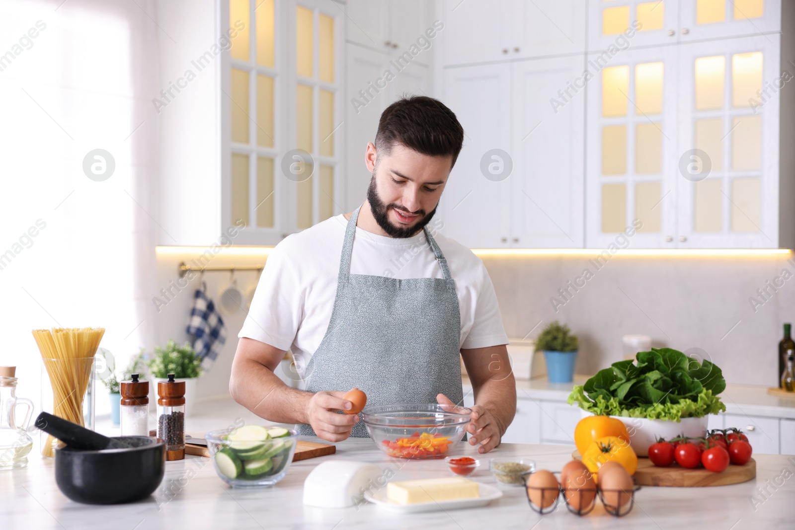 Photo of Smiling man cooking at table in kitchen