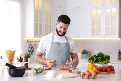 Photo of Smiling man cooking at table in kitchen
