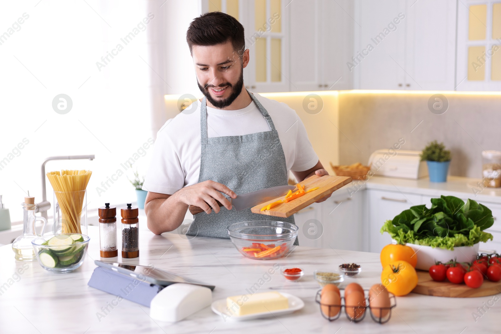 Photo of Smiling man cooking at table in kitchen