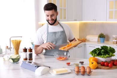 Photo of Smiling man cooking at table in kitchen