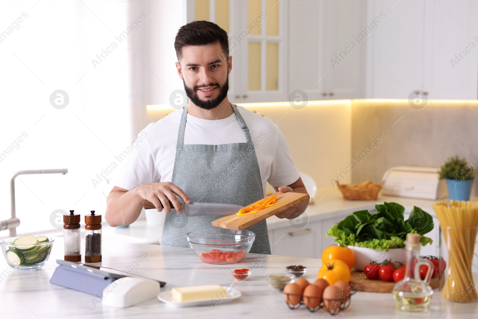 Photo of Smiling man cooking at table in kitchen