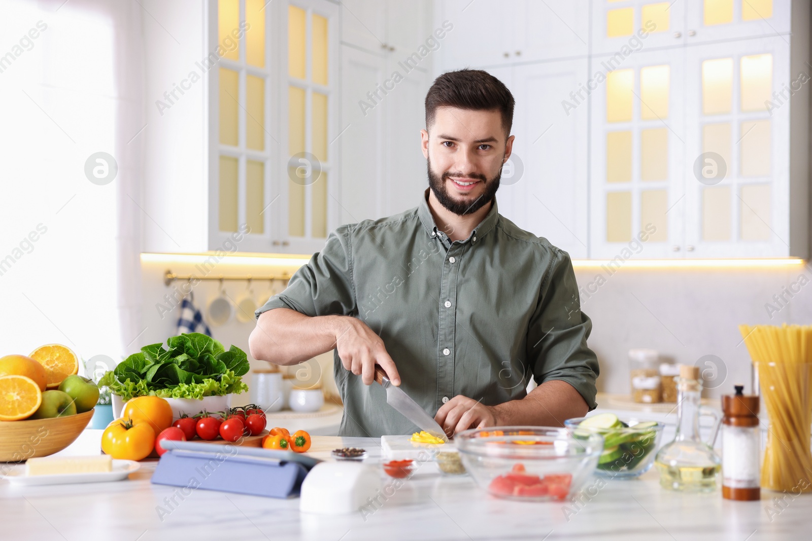 Photo of Smiling man cooking at table in kitchen