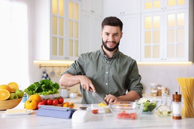 Photo of Smiling man cooking at table in kitchen