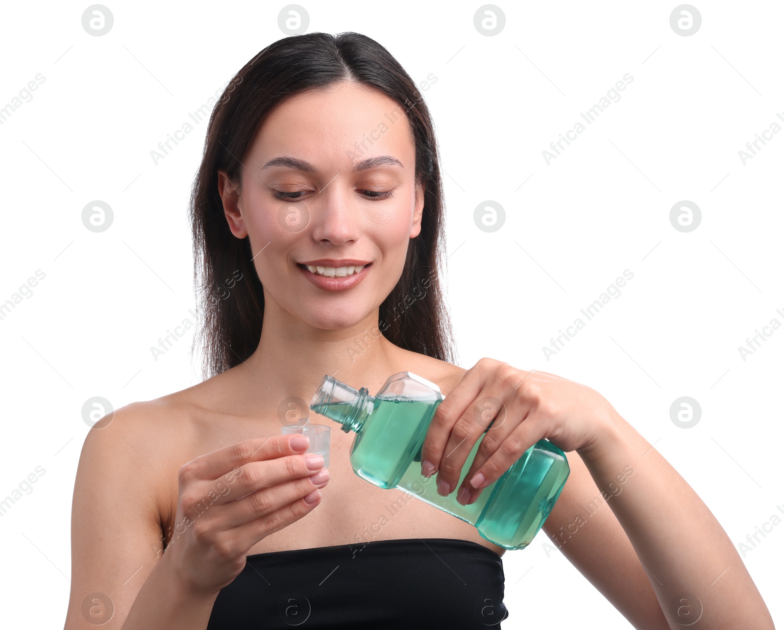 Photo of Smiling young woman pouring mouthwash into cap against white background. Oral hygiene