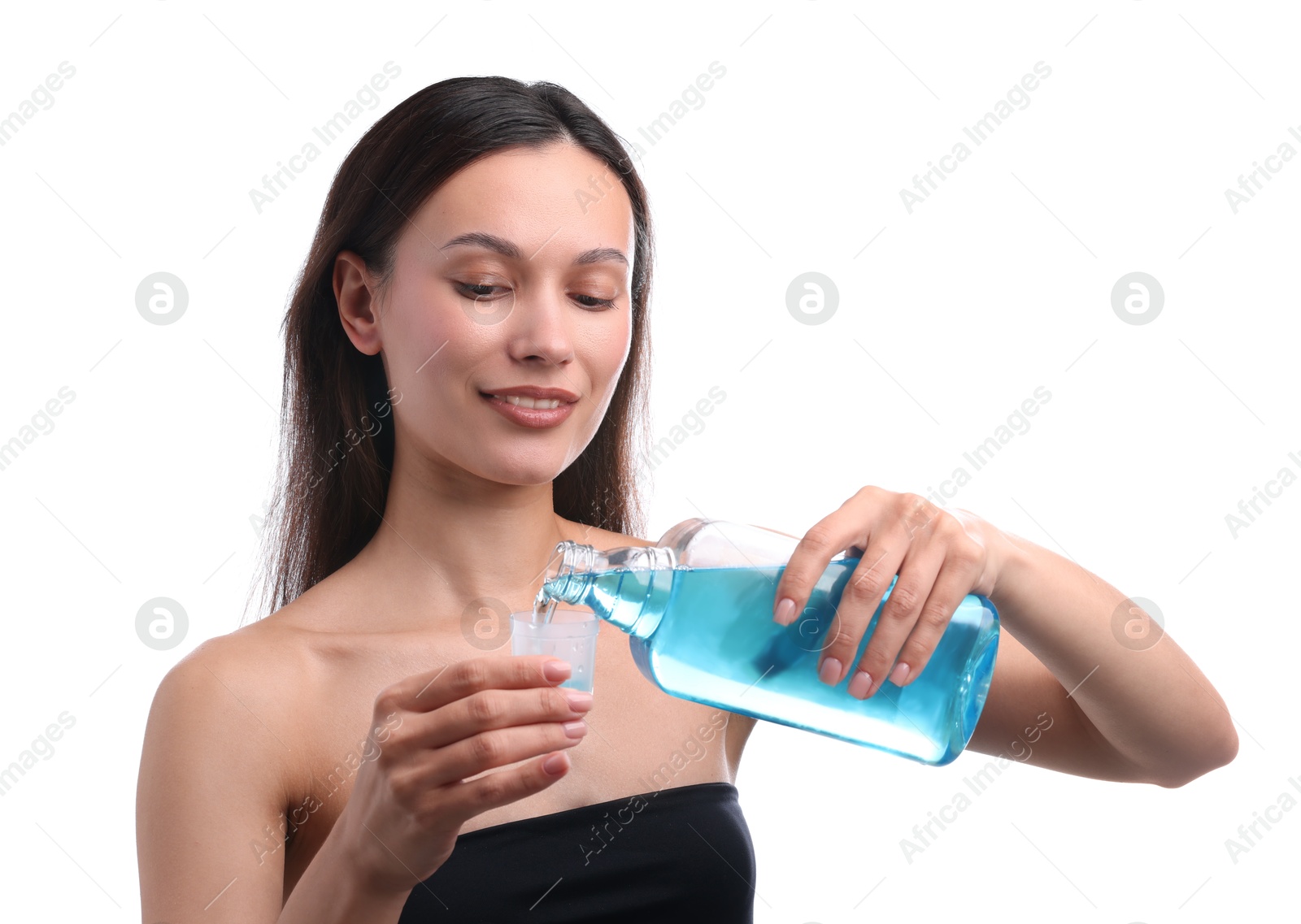 Photo of Smiling young woman pouring mouthwash into cap against white background. Oral hygiene