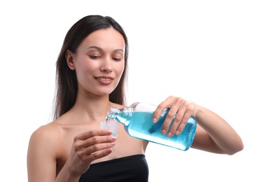 Photo of Smiling young woman pouring mouthwash into cap against white background. Oral hygiene