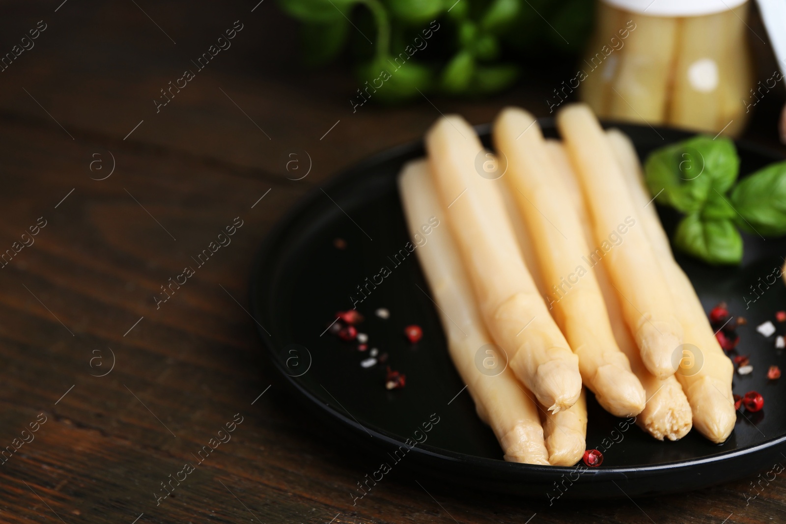 Pickled asparagus and spices on wooden table, closeup. Space for text Photo of Pickled asparagus and spices on wooden table, closeup. Space for text