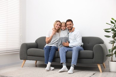 Photo of Happy family spending time together on sofa at home
