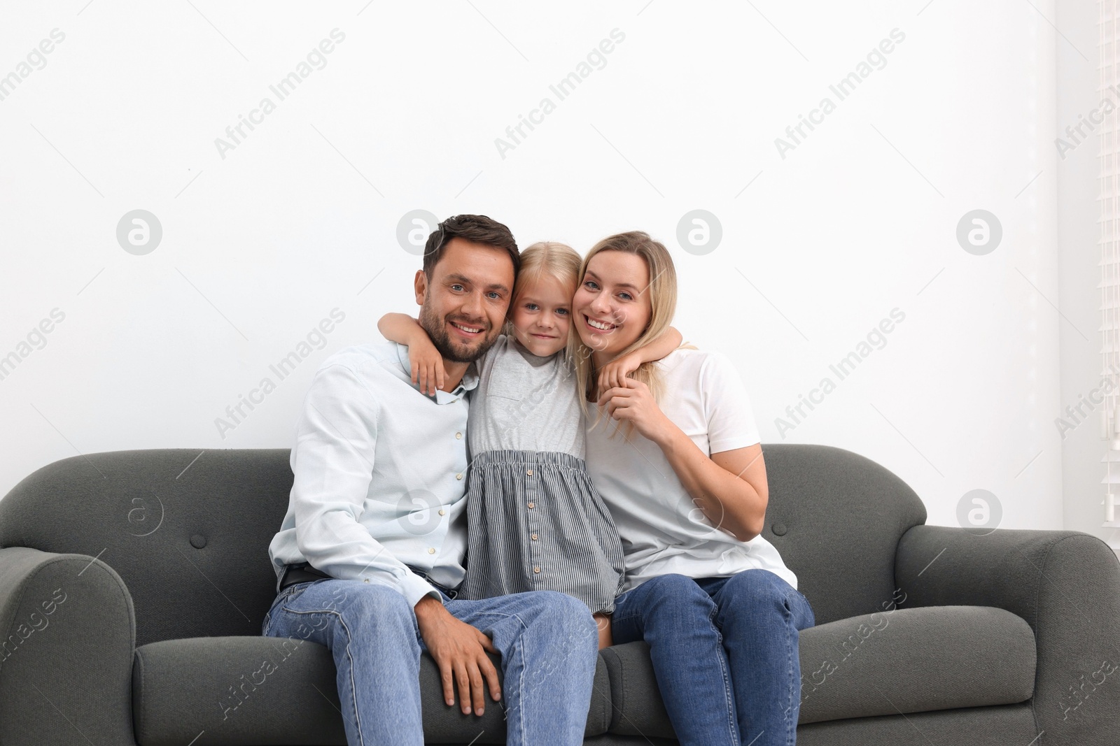 Photo of Happy family spending time together on sofa at home