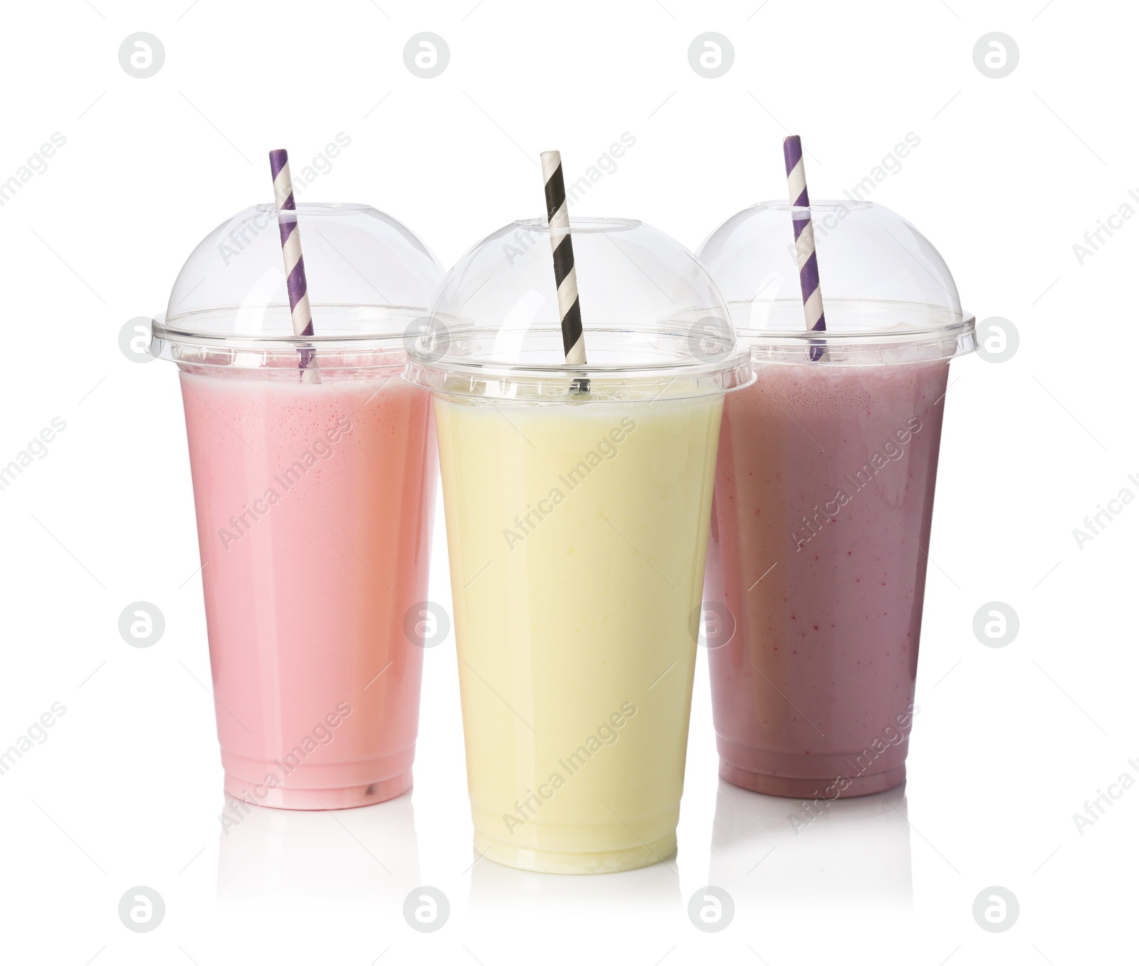Photo of Milkshakes of different flavors in plastic cups isolated on white